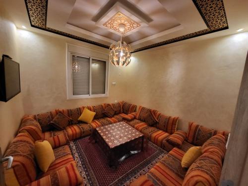 salon z kanapą i stołem w obiekcie Appartement Anza Agadir Meftah Sahel w mieście Agadir