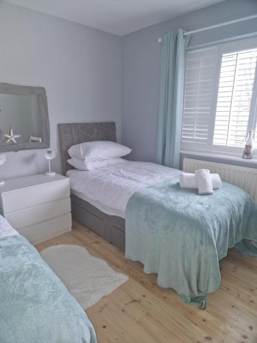 um quarto com 2 camas individuais e uma janela em The Haven em Beadnell