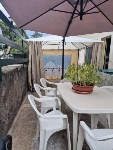 a white table and chairs with an umbrella at Althea Etna Garden in Nicolosi