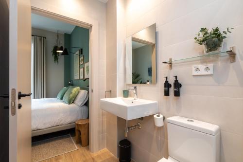 a bathroom with a sink and a toilet and a bed at Moontels Mercado de Ruzafa in Valencia