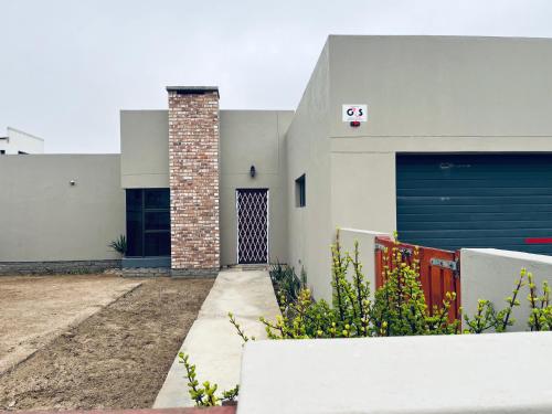 a house with a gate and two garage doors at Otis Self Catering in Walvis Bay