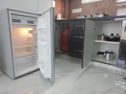 a kitchen with an open refrigerator with its door open at Deccan Stay in Hyderabad