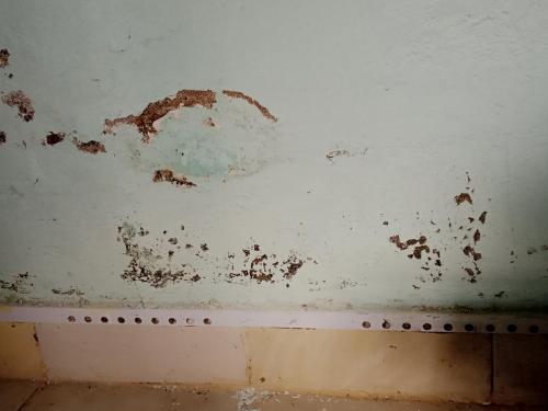 a white wall with chipped paint on it at Black gate in Nanyuki