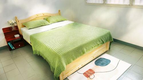 een slaapkamer met een bed met een groen dekbed bij Kerith Lodge in Port Vila