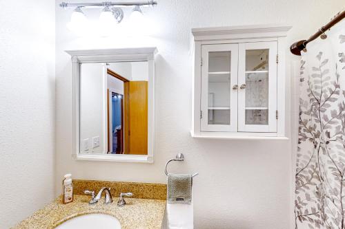 baño con lavabo y 2 espejos en Gather Together Cabin, 