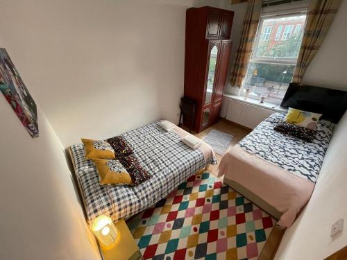 Habitación pequeña con 2 camas y sofá en Spacious Family Flat, en Londres