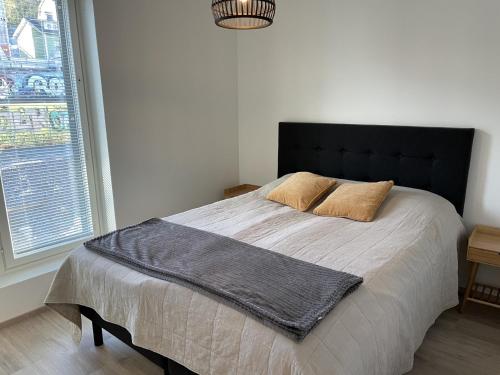 a bedroom with a large bed with two pillows on it at Brand new loft apartment with glazed balcony in Tampere