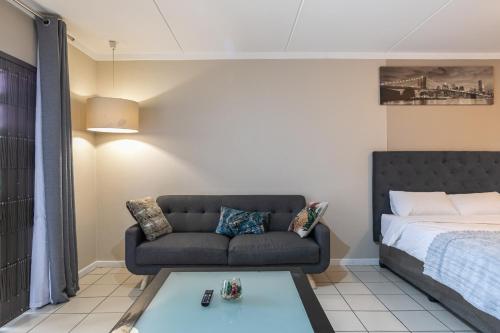 a living room with a couch and a bed at Dainfern K Luxe Apartment in Sandton