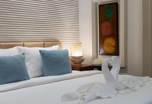 a white bed with a swan decoration on it at Reservoir Hotels in Siem Reap