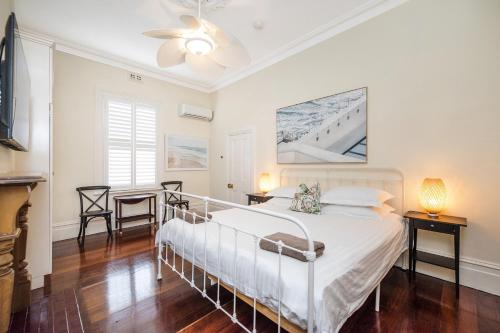 Un dormitorio con una cama blanca en una habitación. en Crepe Myrtle Cottage, en South Fremantle