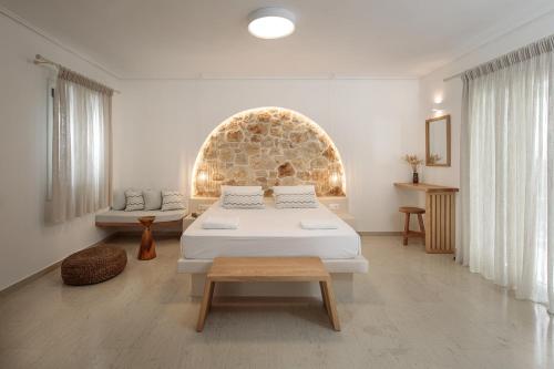 ein Schlafzimmer mit einem Bett, einem Sofa und einem Tisch in der Unterkunft Proteas Hotel & Suites in Agios Prokopios