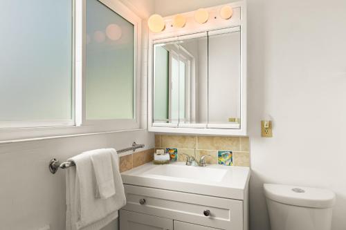 a white bathroom with a sink and a toilet at Gold Coast Getaway in Santa Barbara