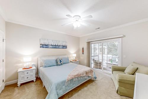 a bedroom with a bed and a couch and a window at A Shore Pleasure in Myrtle Beach