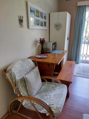 a kitchen with a table and a chair and a refrigerator at Shady Glade in Hillcrest