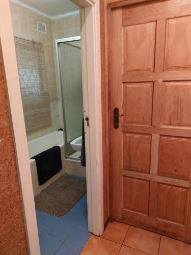 a door to a bathroom with a shower and a tub at Shady Glade in Hillcrest