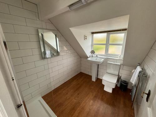 a bathroom with a toilet and a sink and a window at Rylands Farm Guest House in Wilmslow