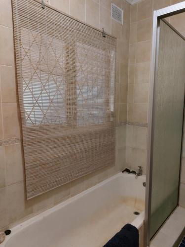 a bathroom with a shower and a tub with a window at Shady Glade in Hillcrest