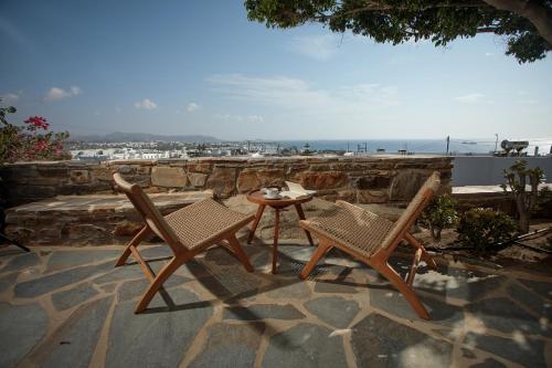 two chairs and a table on a stone patio at Proteas Hotel & Suites in Agios Prokopios