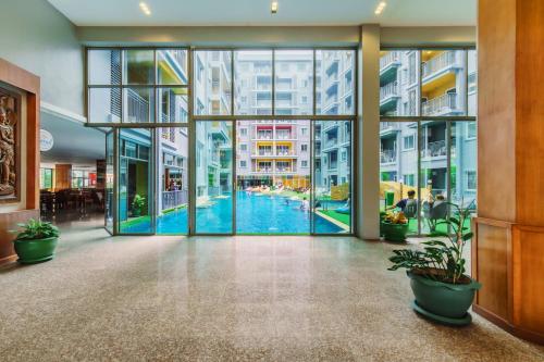 an empty lobby with a pool through the glass doors at Elite Suites Patong in Patong Beach