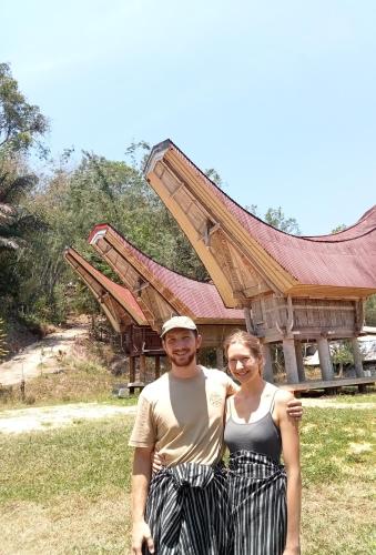 a man and a woman standing in front of a building at NUANSA HOMESTAY Authentic&Hospitality in Rantepao