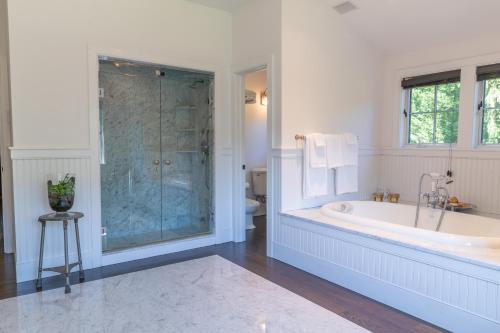 y baño blanco con bañera y ducha. en Cedar Crest Retreat en Southampton