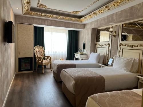 a hotel room with two beds and a chair at Hotel Buyuk Hamit in Istanbul