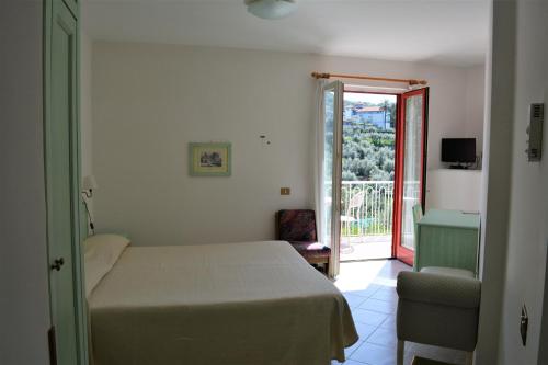 a bedroom with a bed and a door to a balcony at Hotel Dania in Sorrento