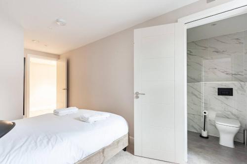 a bedroom with a bed and a shower and a toilet at Aire Apartments (Central) - Executive City Center Apartments in Leeds