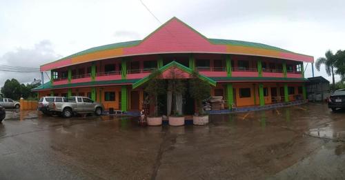 ein Gebäude im Regen auf einem Parkplatz in der Unterkunft ที่พักสกลนคร กิตติวัฒน์อพาร์ทเม้นท์&รีสอร์ท in Sakon Nakhon