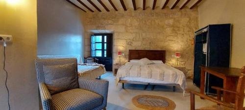 een slaapkamer met een bed en een stoel in een kamer bij Jardines de Colón in Alcalá la Real