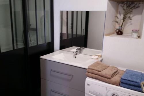 a white bathroom with a sink and a mirror at Le Chai Rit in Rivedoux-Plage