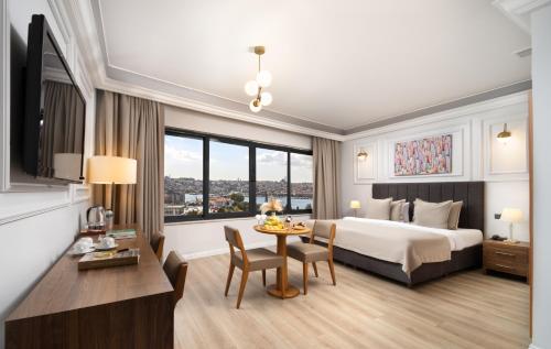 a hotel room with a bed and a table with chairs at Elan Hotel Istanbul Pera in Istanbul