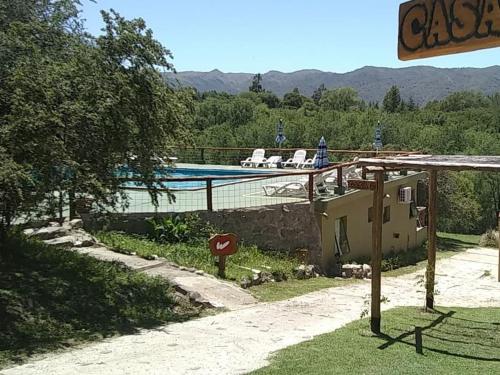 a house with a swimming pool with two chairs on the roof at Cabañas Wairoa Haus in Villa General Belgrano