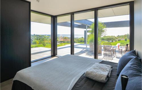 エーベルトフトにあるNice Home In Ebeltoft With 3 Bedrooms And Wifiのベッドルーム1室(ベッド1台、大きなガラス窓付)