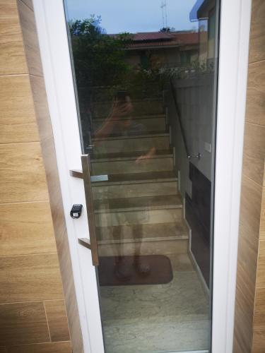 a person standing on stairs through a glass door at B&B Tonnarella Beach in Torre Forte