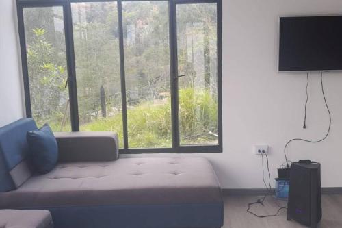 sala de estar con sofá y ventana grande en Cabaña en Guayabal de Siquima en Guayabal de Síquima