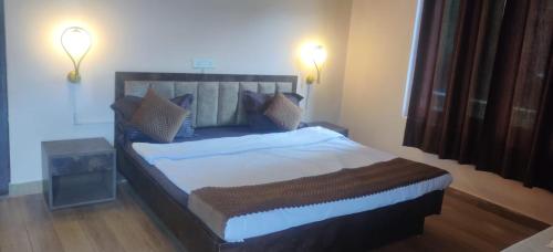um quarto com uma cama grande e 2 luzes acesas em Mount and Lakes em Bhimtal