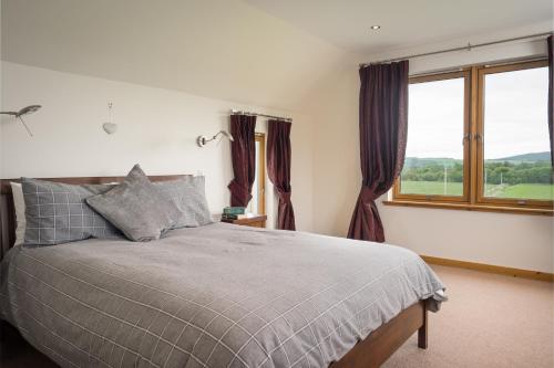 una camera da letto con un letto e una grande finestra di Burnbrae Lodge - Seasgair Lodges a Carrbridge