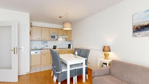 uma cozinha e sala de jantar com mesa e cadeiras em Apartmenthaus Binzer Sterne Haus 1 em Binz