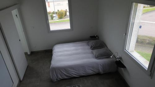 une petite chambre avec un lit et deux fenêtres dans l'établissement L ATELIER, à Courtisols