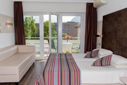 a hotel room with two beds and a balcony at Colorado Hotel in Lugano