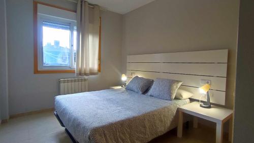 um quarto com uma cama grande e uma janela em Apartamento en Miño em La Coruña