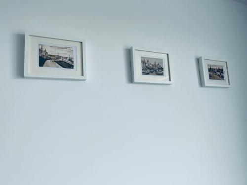 three framed photographs on a wall in a room at Apartament Stary Szczecin in Szczecin