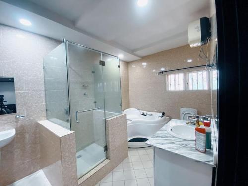 een badkamer met een douche, een wastafel en een toilet bij Pinnacle Holiday Home Five bedroom House in Lekki