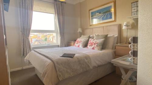 a bedroom with a bed with a book on it at St John's Guest House in Weymouth