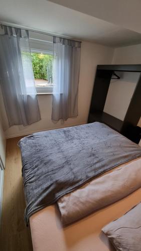 a large bed in a room with a window at Unterkunft Sanic in Kronberg im Taunus