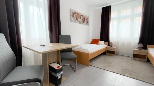 a small room with a desk and a bed at MOTEL DARIA Hennigsdorf Berlin in Hennigsdorf