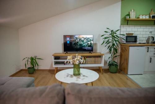 Una sala de estar con un sofá y una mesa con flores. en Victoria Apartment, en Ohrid