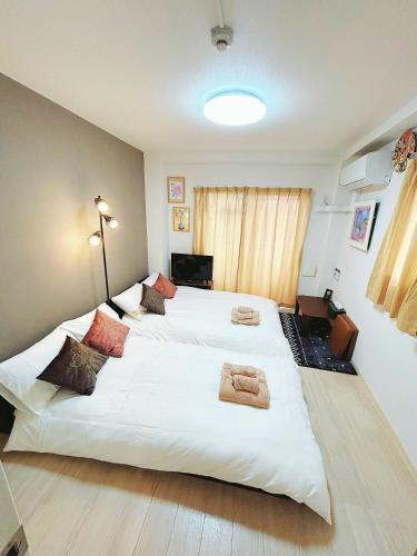a bedroom with two beds with towels on them at Tokyo Skytree Home Skytree View Hikifune in Tokyo