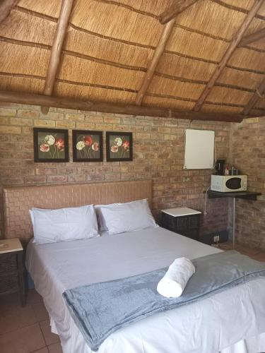 a bedroom with a large white bed in a room at Pepe Piatto Lodge in Grootvlei